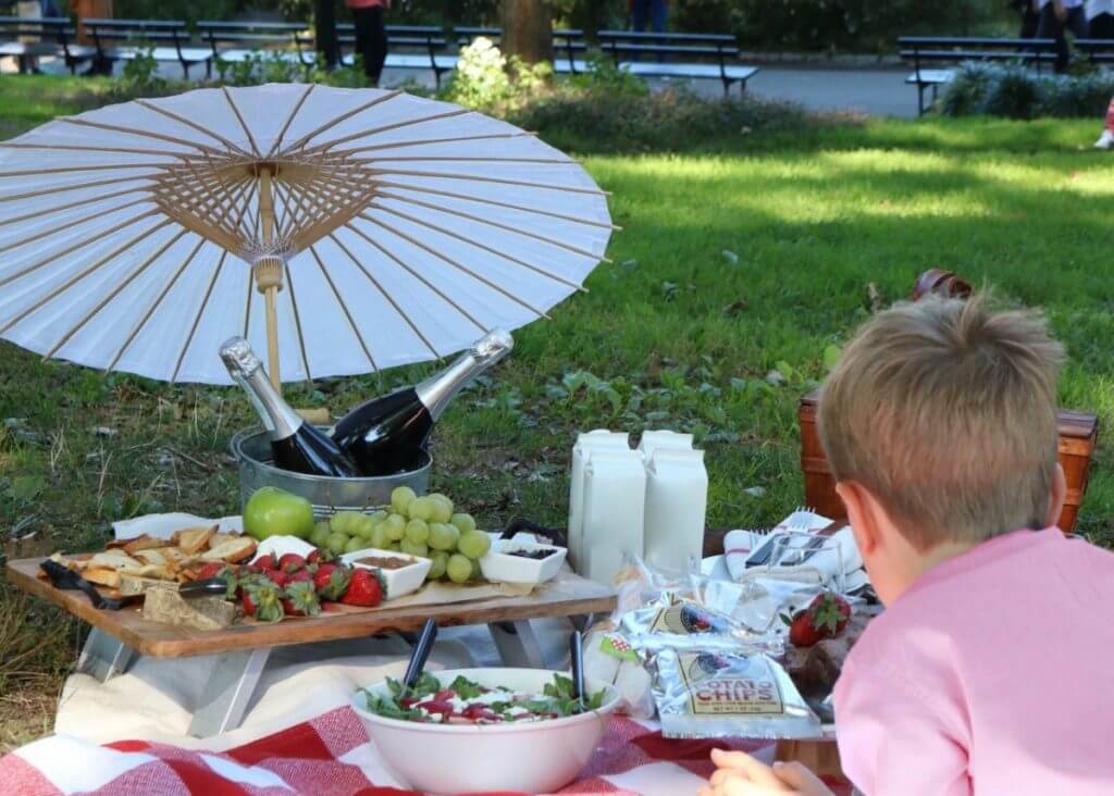 Boy looking at picnic foods. 