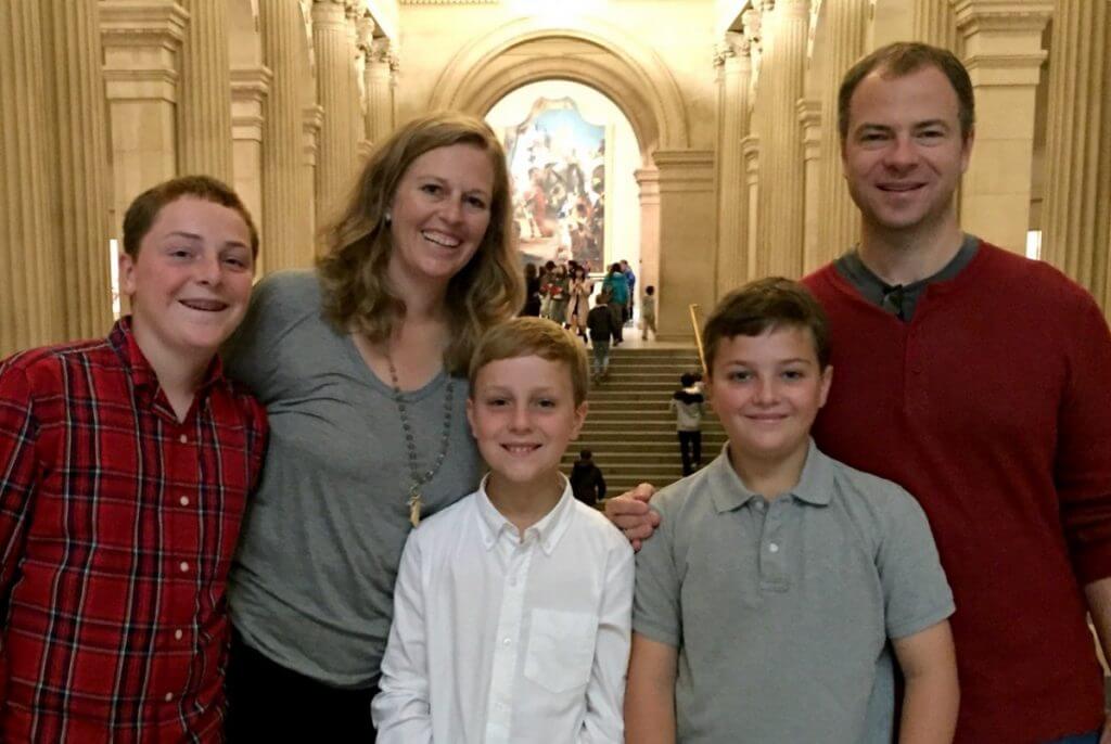 Kirsten and her family smiling in the museum. 