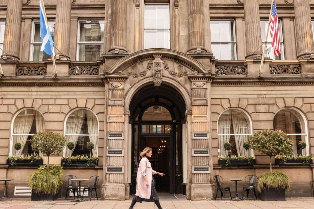Image of the front of the Intercontinental, The George 5* with a woman walking past.