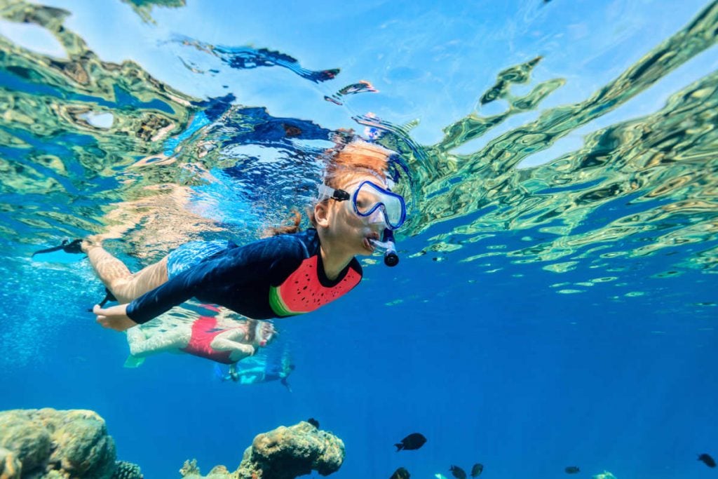 Kid snorkeling with fish
