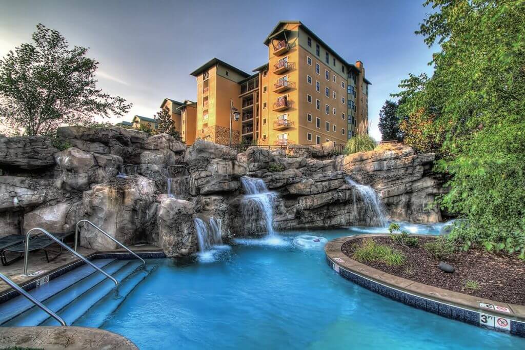 Riverstone Resort Hotel rising above a pool with rock waterfalls. 