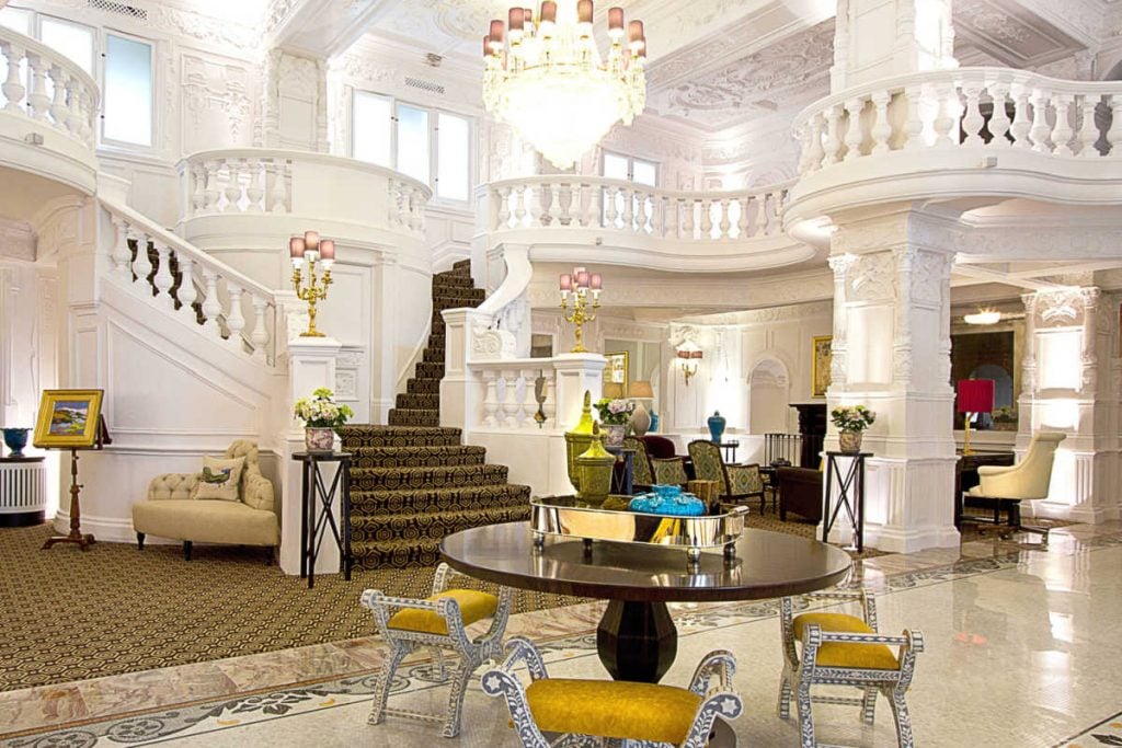 Lobby with majestic stairs and white balusters at St Ermins hotel in London.