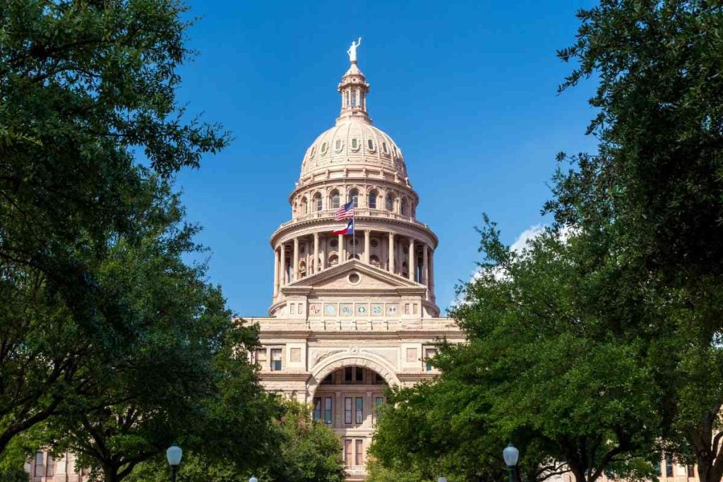 View of Texas State Capitol Building between trees.