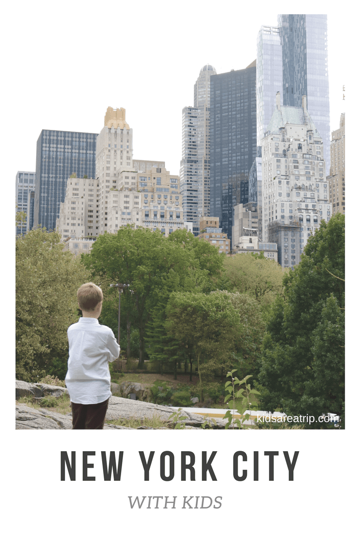 Boy in Central Park looking up at NYC buildings. 